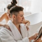 Para w wannie przytulona podczas wspólnego czytania książki