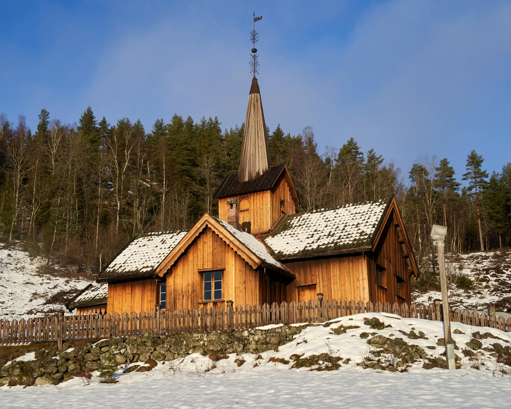 Drewniany kościół Vatnås zimą pośród ośnieżonego krajobrazu