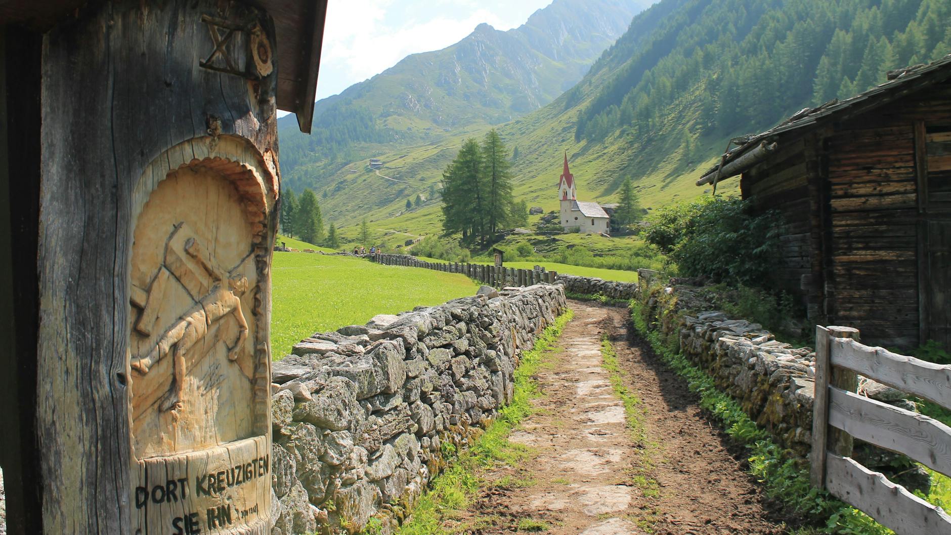Letnia górska ścieżka prowadząca do kościoła z czerwonym dachem