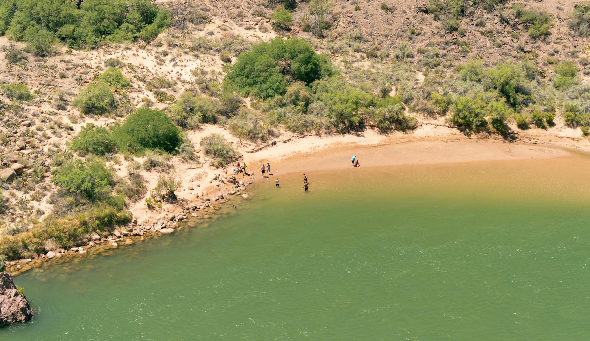 Plaża nad rzeką w głębokim kanionie z ludźmi odpoczywającymi nad wodą