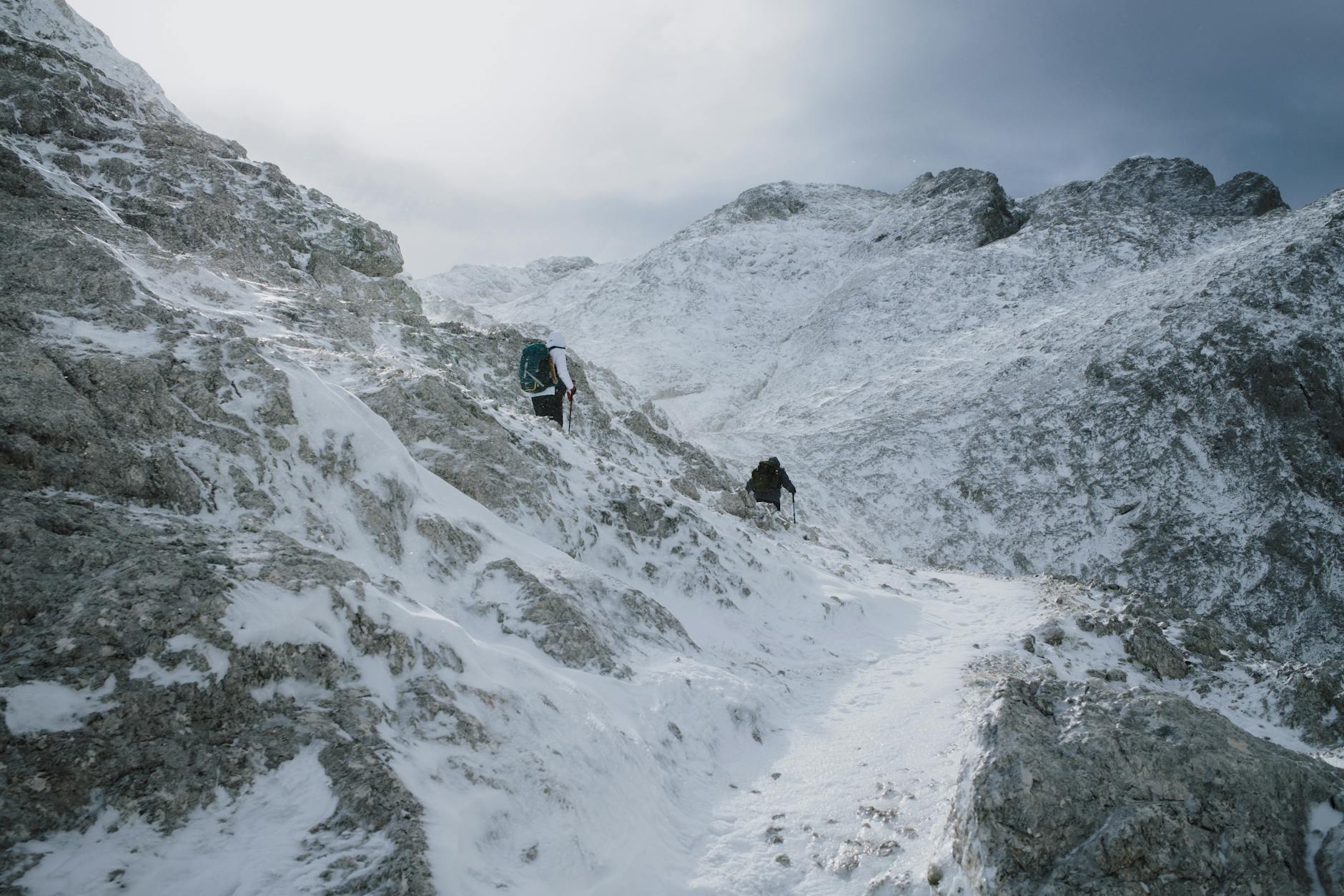 Turyści idą zimowym szlakiem w zaśnieżonych górach